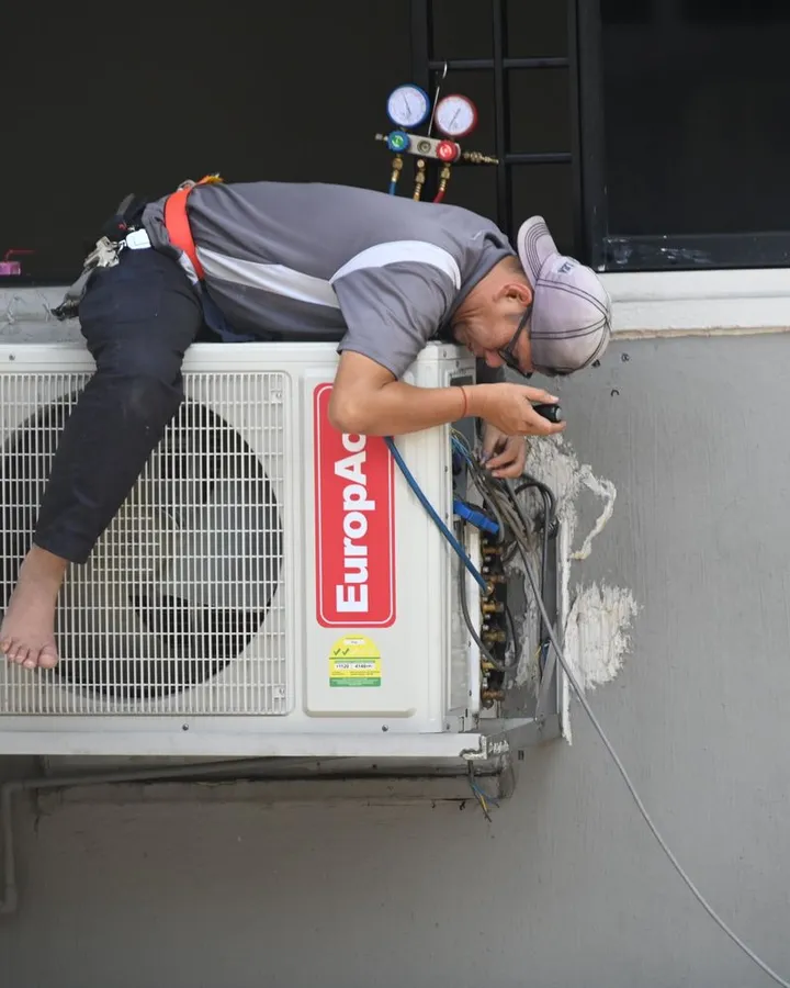 Técnico consertando um ar-condicionado
