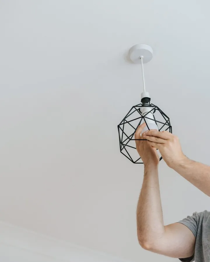 Eletricista instalando uma luminária
